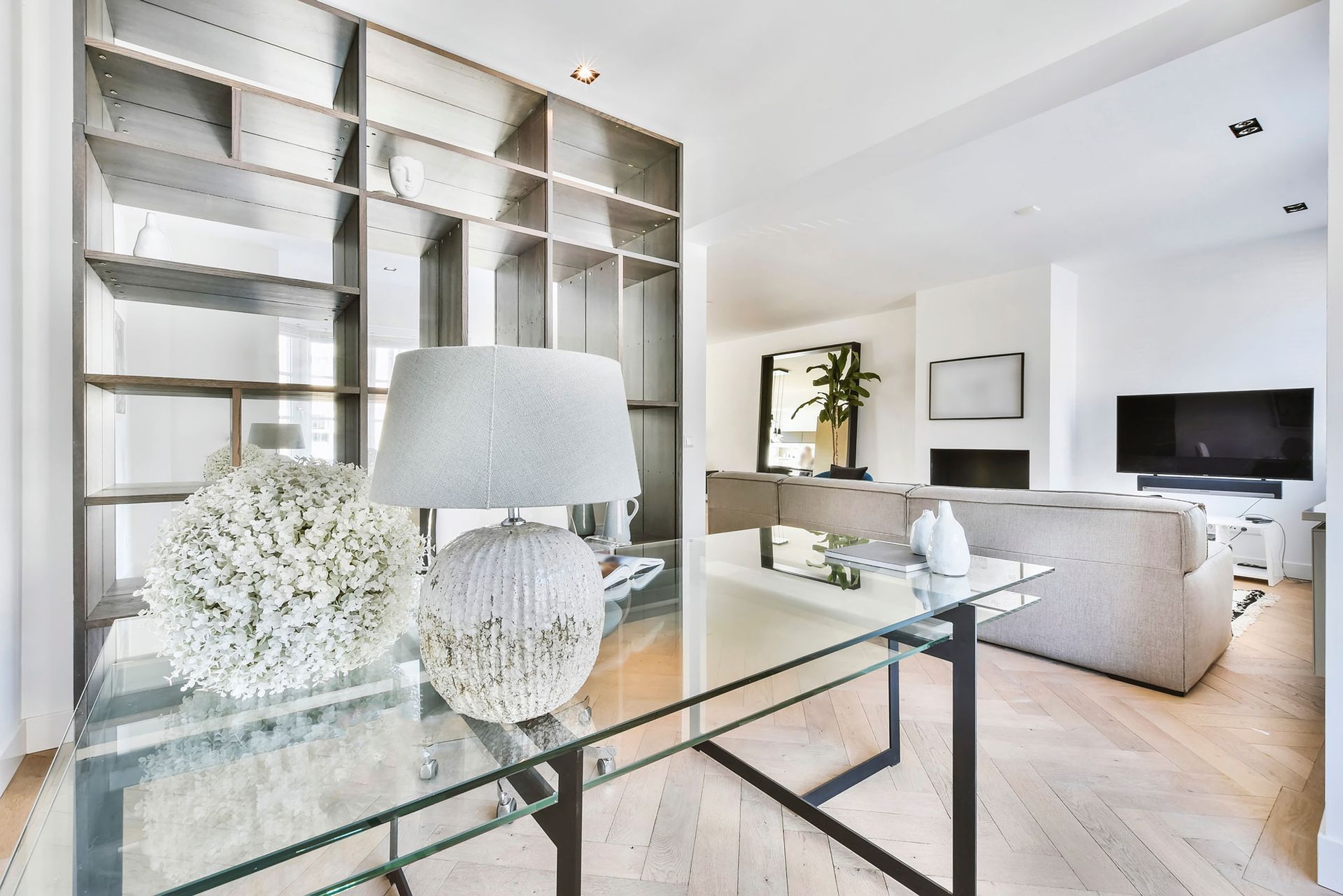 Ein Wohnzimmer mit einem Glastisch und einer Lampe darauf