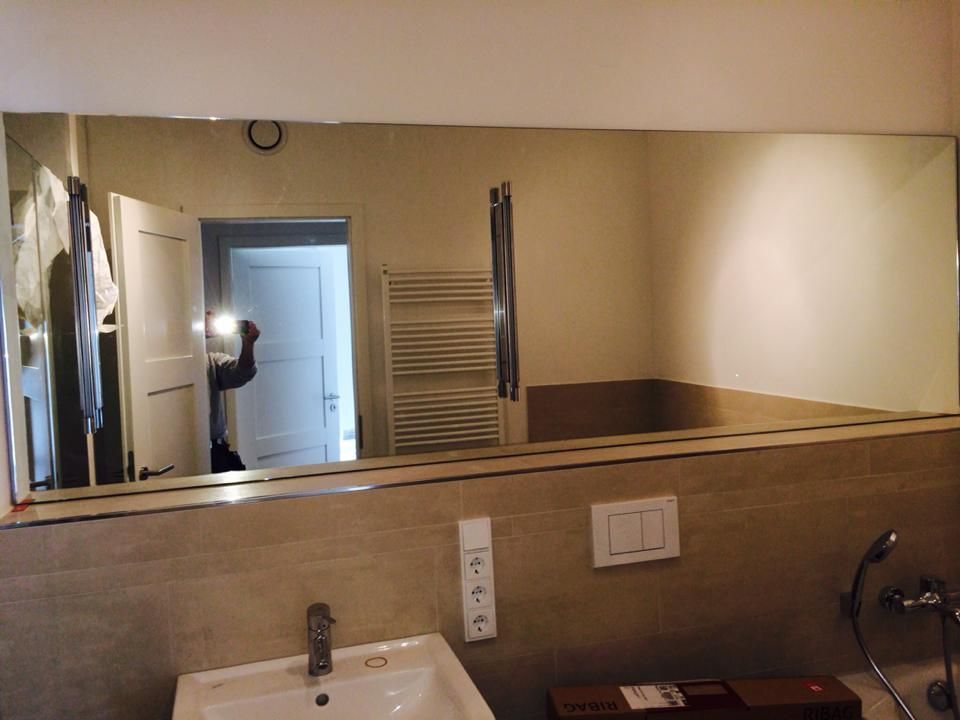 Ein Badezimmer mit Waschbecken und großem Spiegel