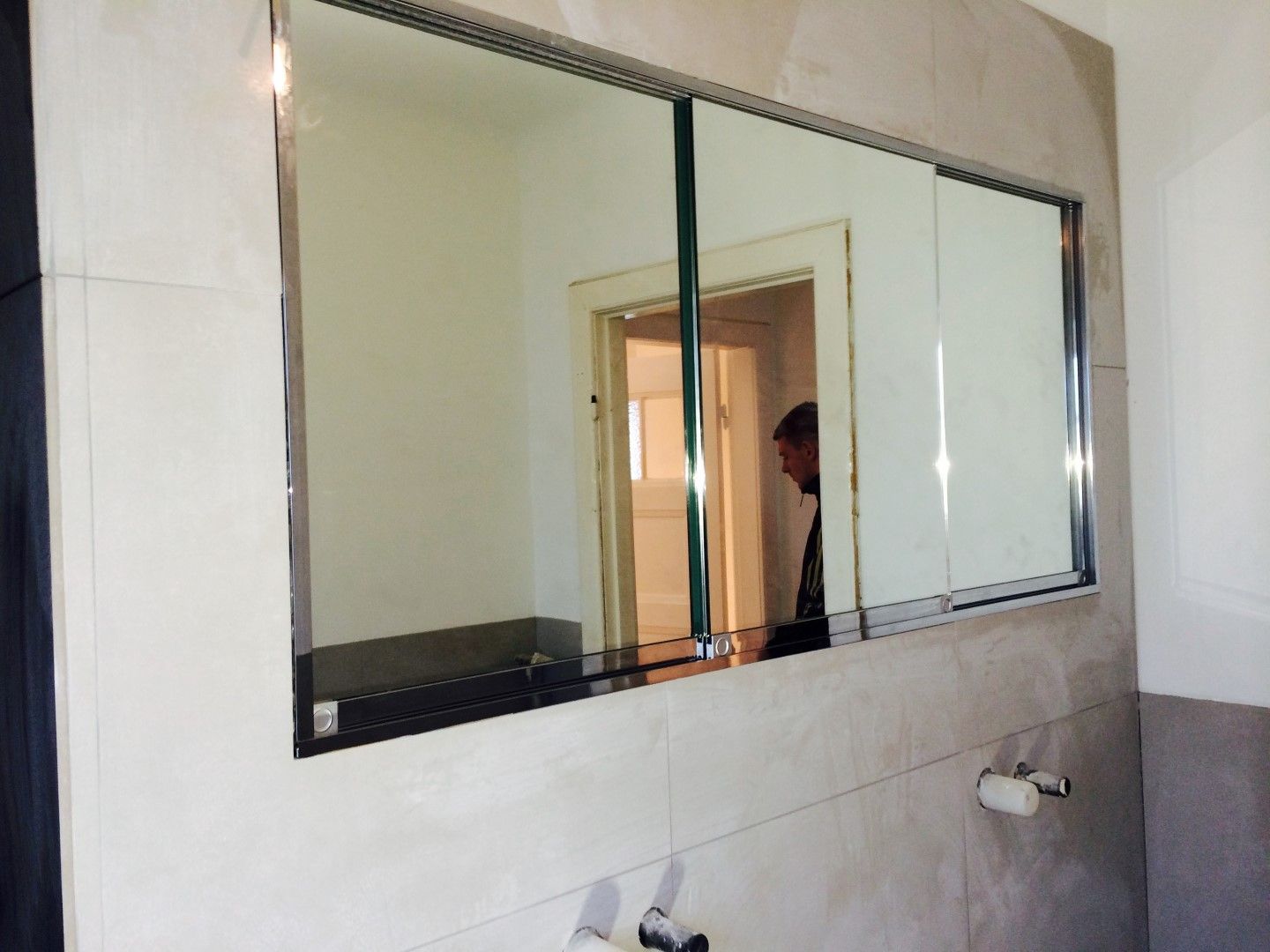 Ein Badezimmer mit einem großen Spiegel an der Wand