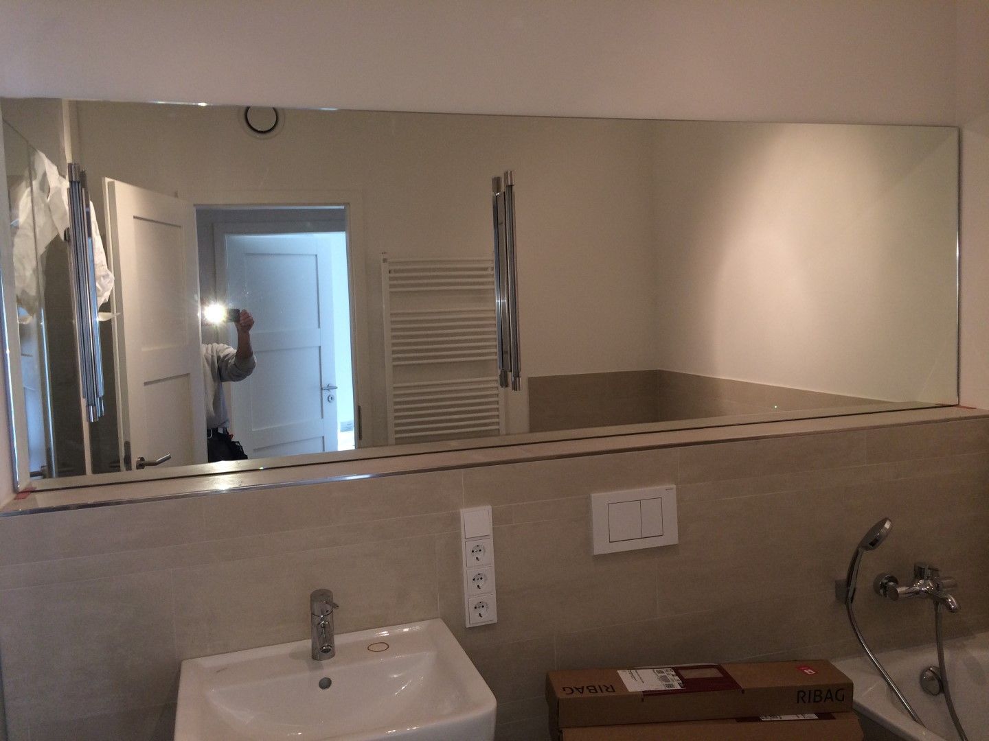 Ein Badezimmer mit Waschbecken und großem Spiegel