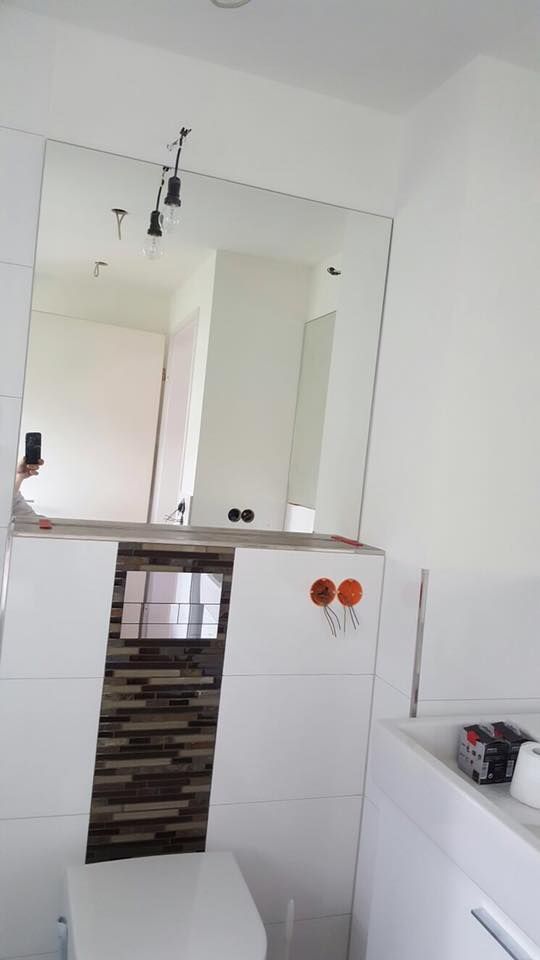 Ein Badezimmer mit Toilette, Waschbecken und Spiegel.