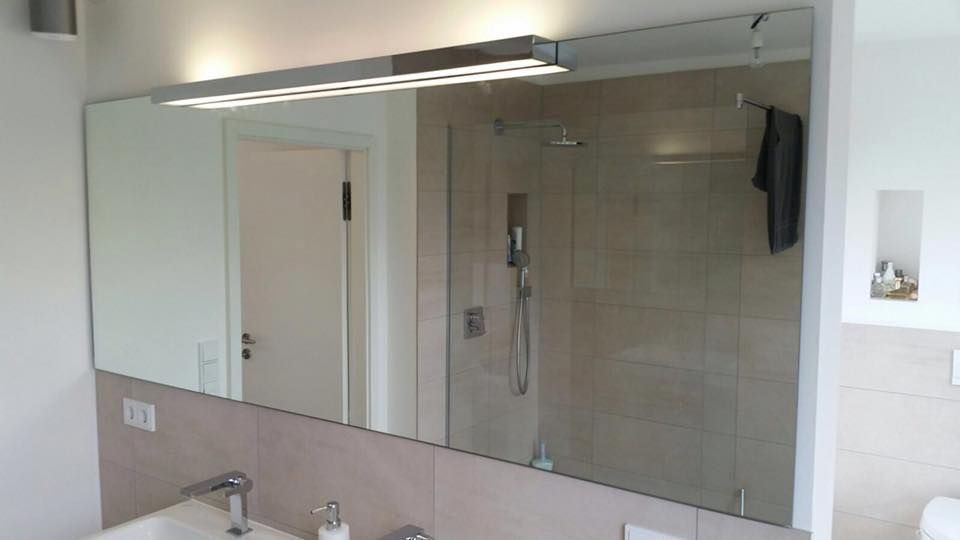 Ein Badezimmer mit großem Spiegel und Waschbecken