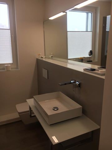 Ein Badezimmer mit Waschbecken, Toilette und Spiegel.