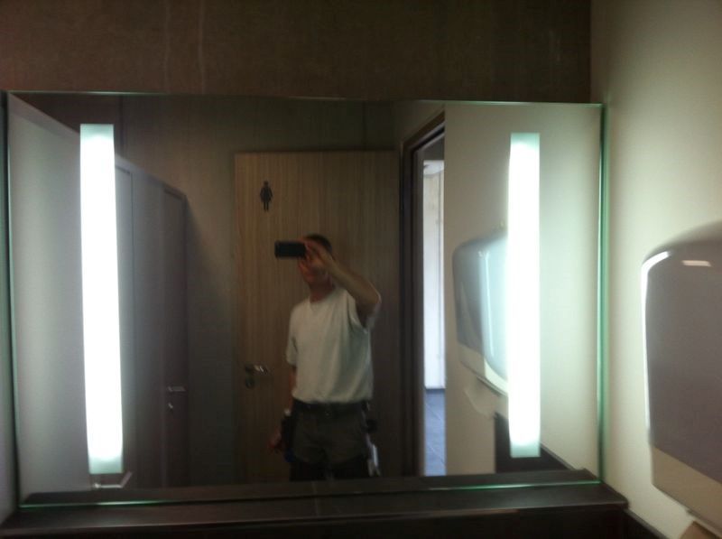 Ein Mann, der ein Foto von sich selbst in einem Badezimmerspiegel macht