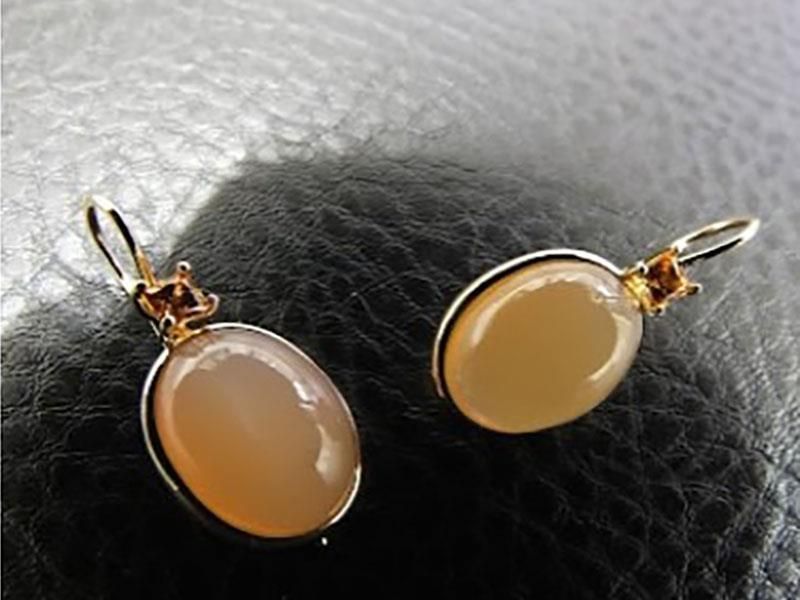 Ein Paar Ohrringe liegen auf einer schwarzen Oberfläche