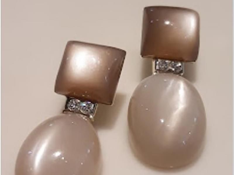 Ein Paar Ohrringe liegen auf einer weißen Oberfläche.