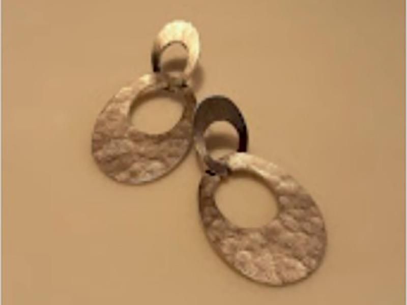 Ein Paar Ohrringe liegen auf einem Tisch.