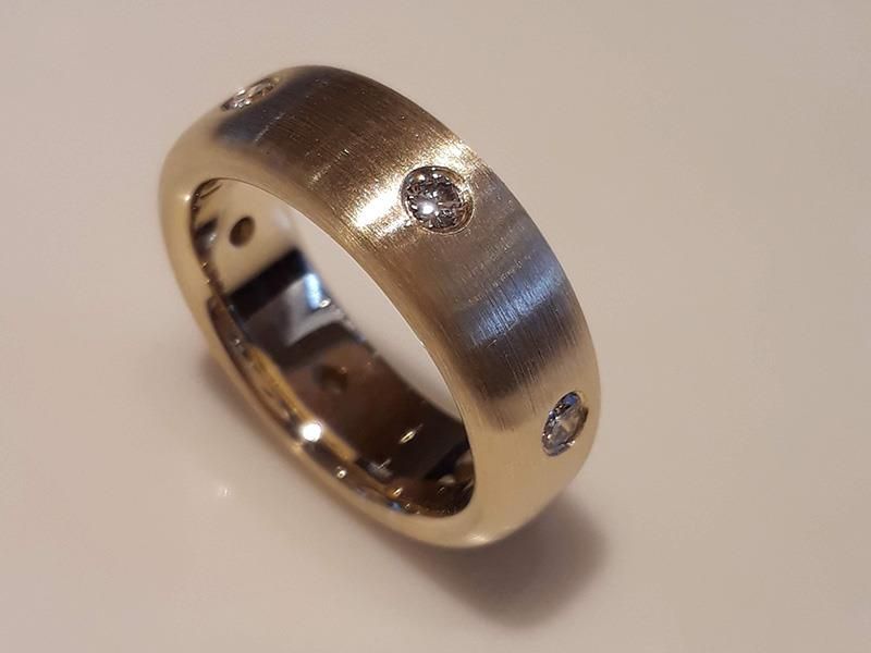 Ein goldener Ring mit drei Diamanten darauf