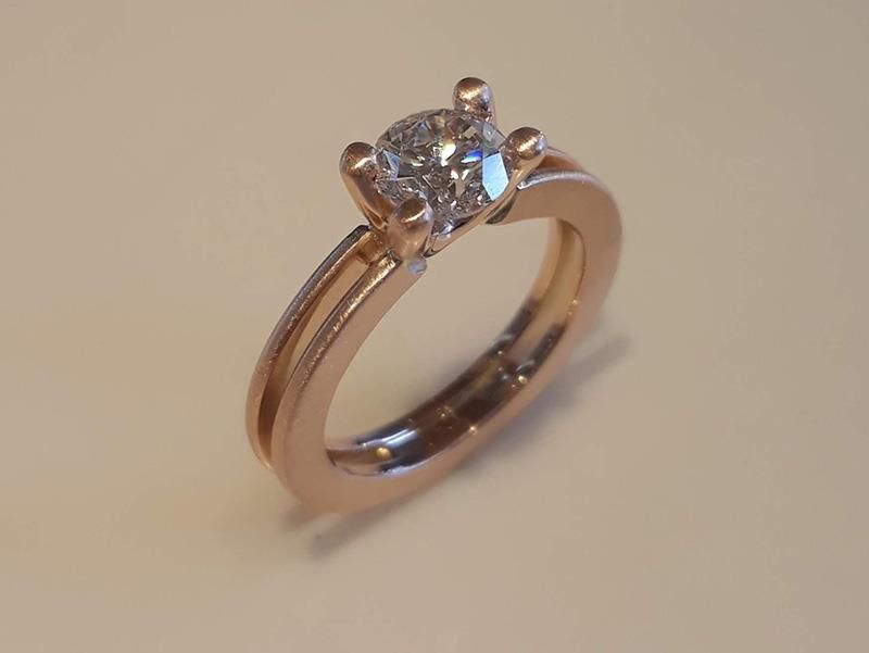 Ein Diamantring liegt auf einer weißen Oberfläche