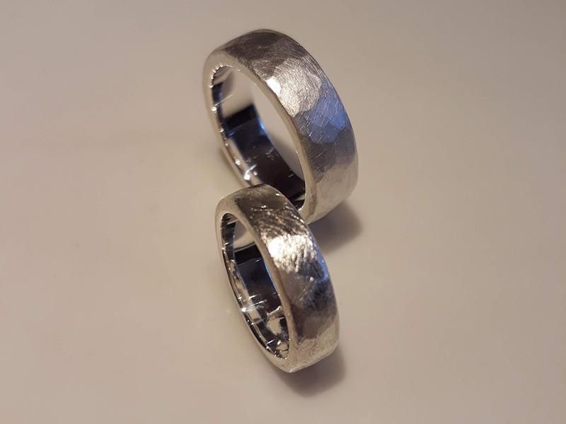 Auf einer weißen Fläche sind zwei silberne Ringe übereinander gestapelt.