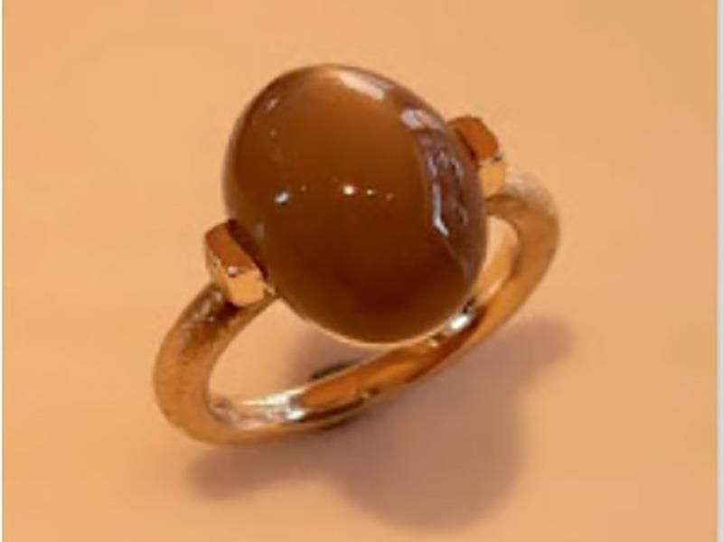 Ein goldener Ring mit einem braunen Stein darauf
