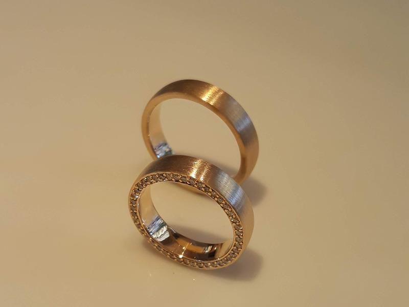 Ein Paar Eheringe, die übereinander auf einem Tisch liegen