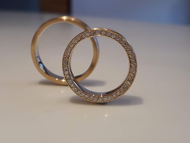 Zwei Eheringe liegen auf einer weißen Fläche