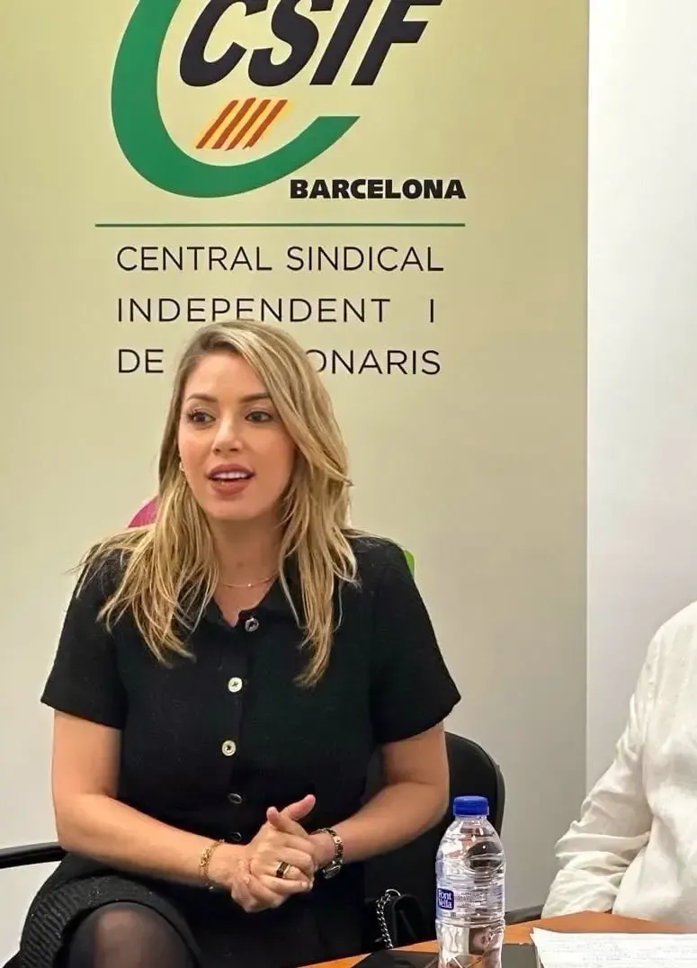 Mujer hablando en una mesa de prensa del CSIF Barcelona, ​​con el logotipo y el letrero detrás de ella.