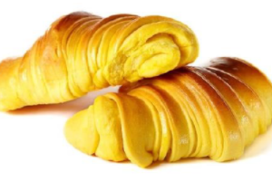 Dois croissants empilhados um sobre o outro em uma superfície branca