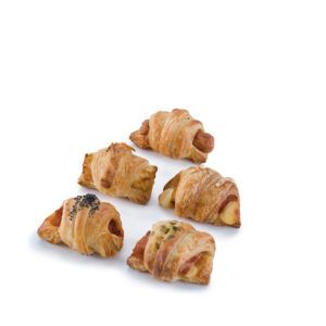 Um monte de pastéis envoltos em massa folhada sobre uma superfície branca