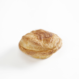 Um pequeno bolo está sobre uma superfície branca.