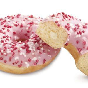 Um donut com cobertura rosa e granulado vermelho foi cortado ao meio
