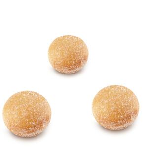 Três donuts estão um em cima do outro em uma superfície branca.