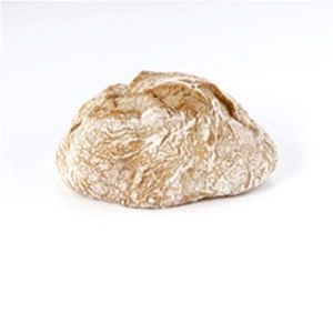 Um pedaço de pão está sobre uma superfície branca