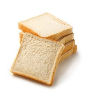 Fatias de pão branco empilhadas umas sobre as outras sobre um fundo branco.