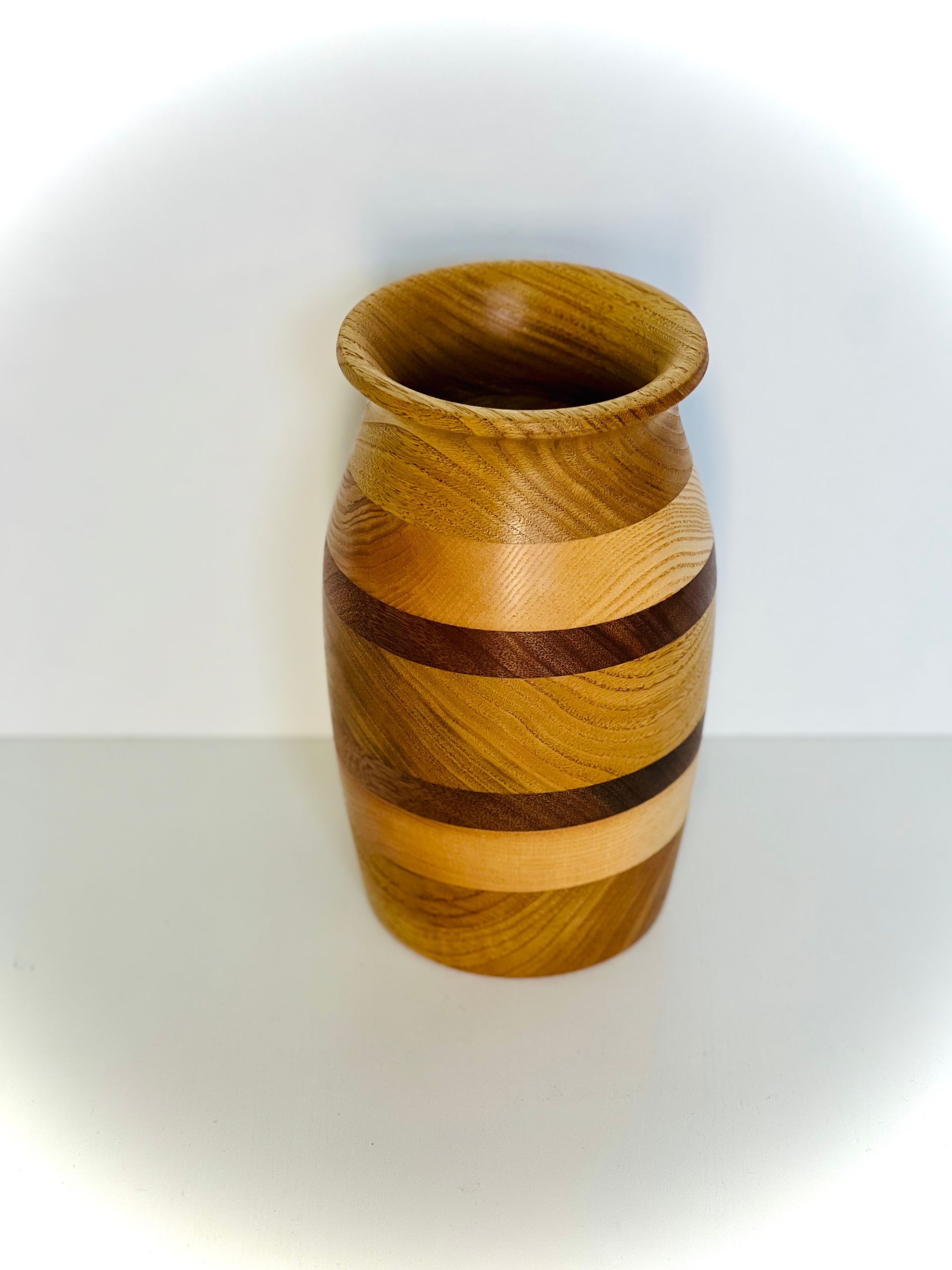 Vase en bois rayé à bord évasé sur fond blanc