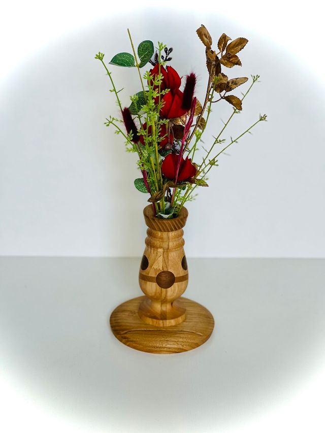 Vase décoratif avec des fleurs rouges et séchées.