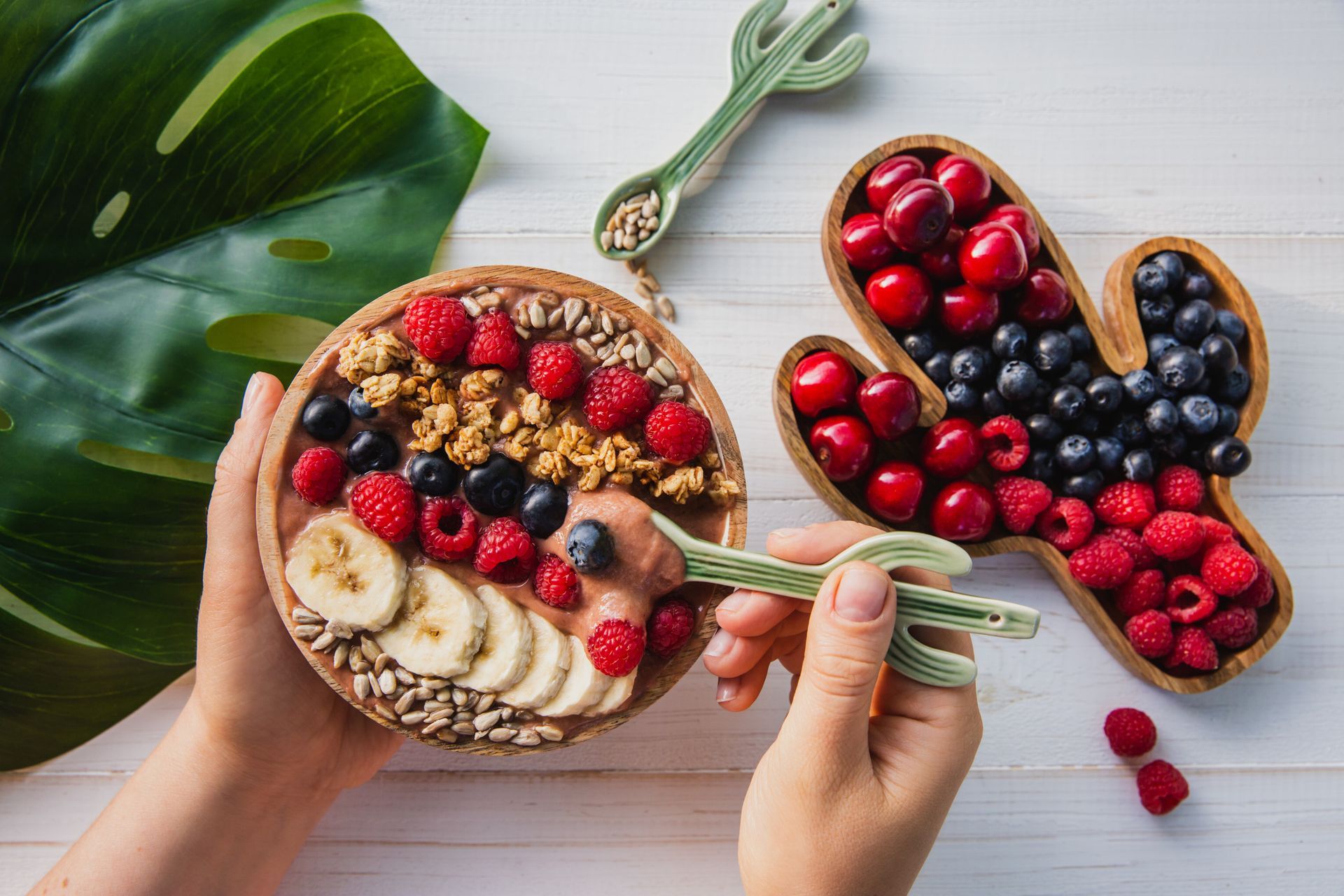 Una persona está comiendo un tazón de fruta con una cuchara.