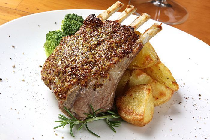 Un plato blanco cubierto con un trozo de carne y patatas.