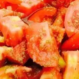 Tomates rojos picados con hierbas y especias. Primer plano de ingredientes frescos y coloridos.