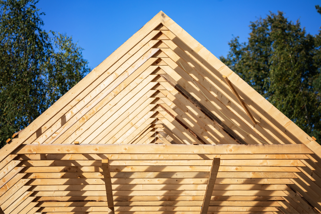 Un toit en bois en construction avec des arbres en arrière-plan.