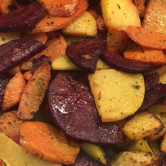 Paahdettuja juureksia, kuten oransseja porkkanoita ja violetteja punajuuria, maustettuna.
