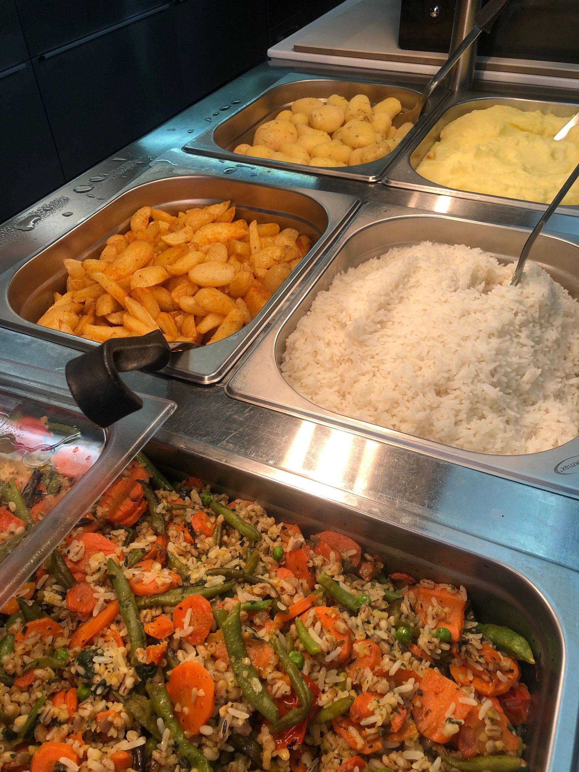 Buffetissa tarjolla paistettuja perunoita, perunamuusia, riisiä ja kasvissekoitusta.