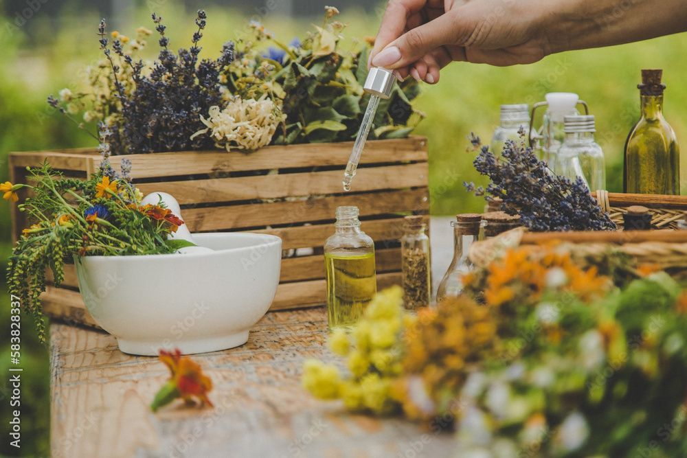 Frau hält Pipette und Flasche mit gelber Flüssigkeit, lächelt. Pflanzen im Hintergrund.