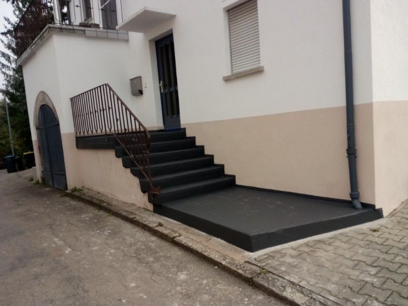 schwarze Treppe vorm Hauseingang