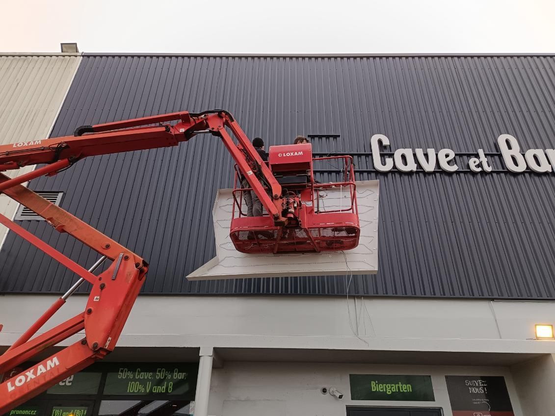 Bar Les Landes Jeux devanture avec verdure, enseigne lumineuse et vitrines ouvertes.
