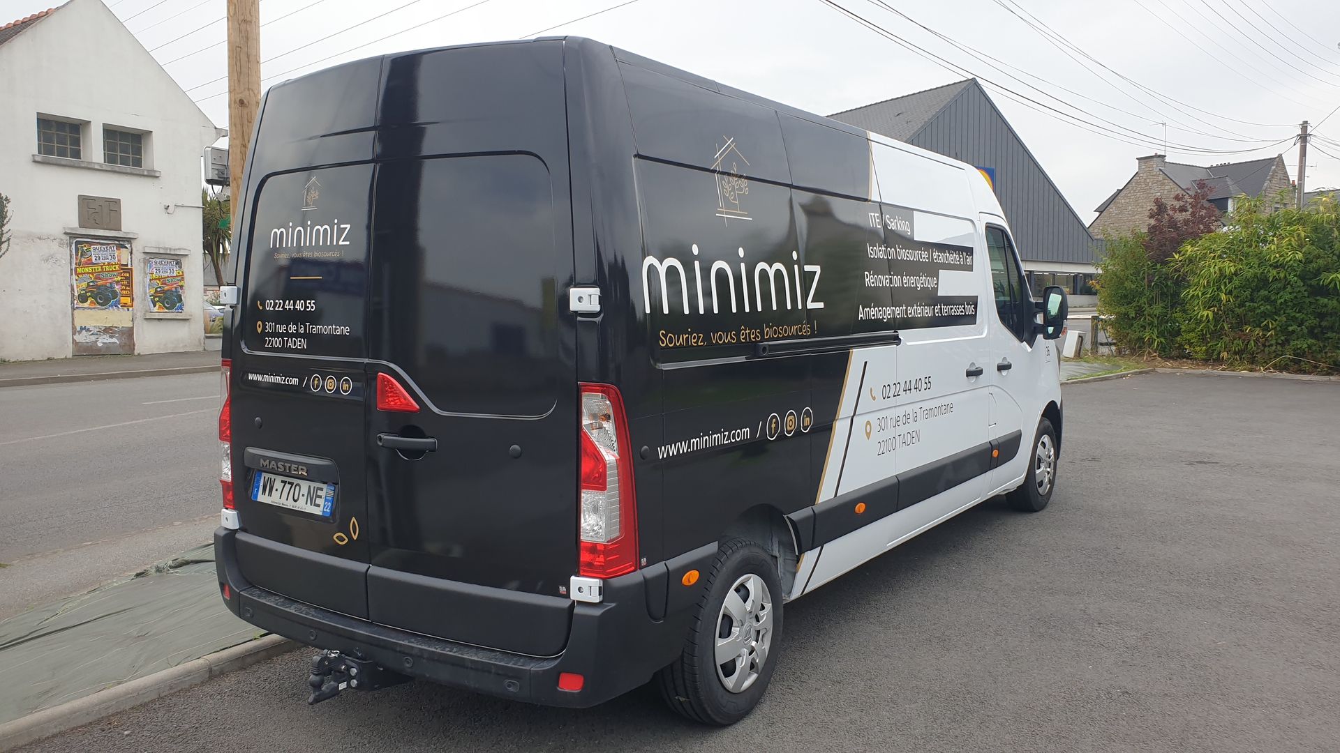 Fourgonnette noire et blanche garée dans une rue, avec le nom de l'entreprise minimiz sur le côté.