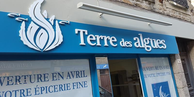 Panneau Terre des algues, épicerie fine au logo bleu et blanc, au dessus de l'entrée.