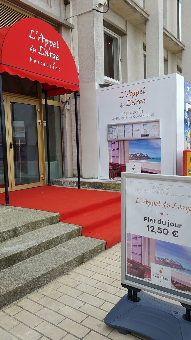 Entrée de l'hôtel avec tapis rouge, auvent et enseigne. Escalier menant à l'étage. Tarif journalier : 73,50 €.