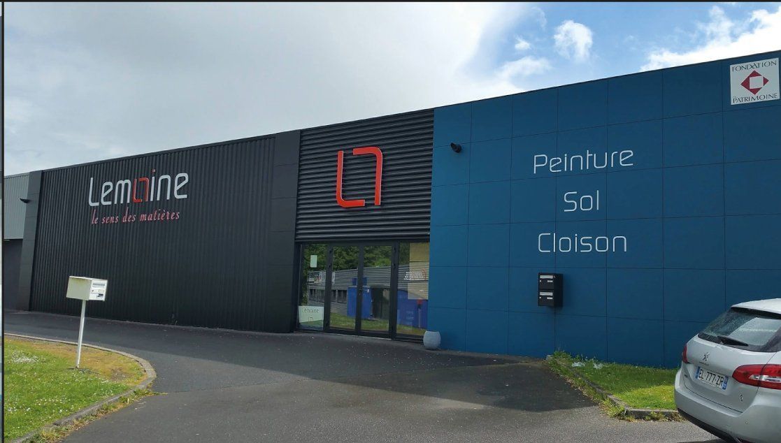 Un bâtiment commercial moderne avec les enseignes  Lamine  et  Aperture Sci Lintent's. Murs gris et bleus.