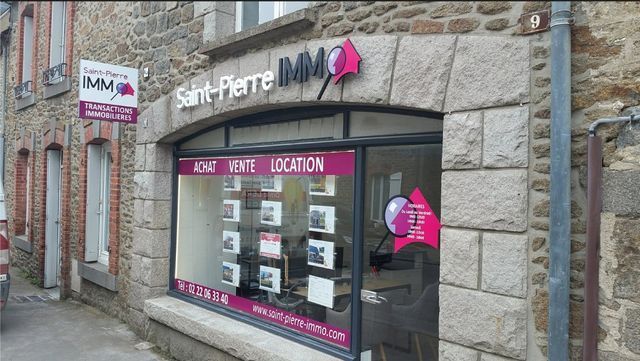 Vitrine de l'agence immobilière Saint-Pierre IMMO aux accents roses et annonces immobilières.