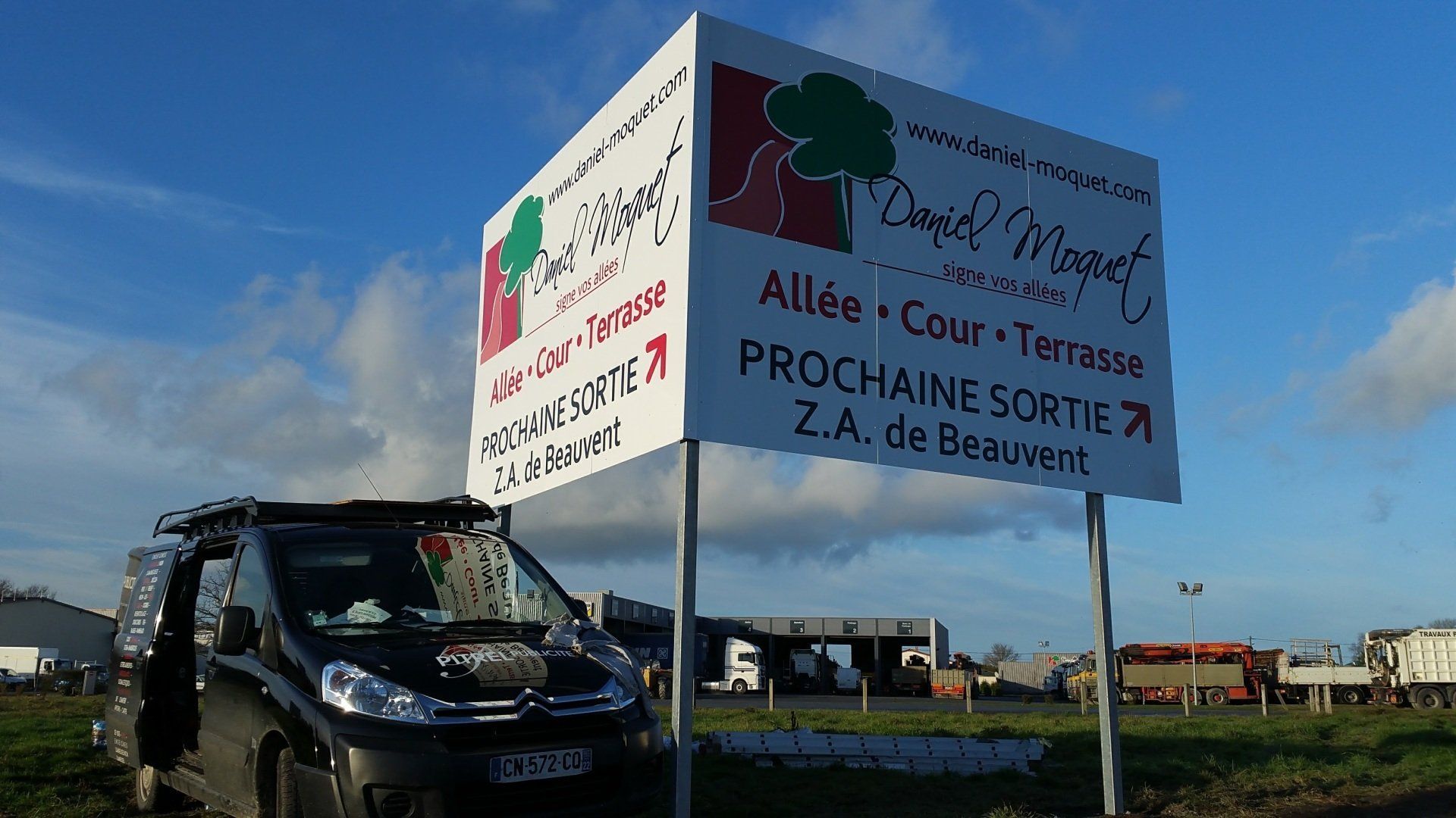 Panneau pour Daniel Moquet pour allée, cour et terrasse, avec une camionnette devant.