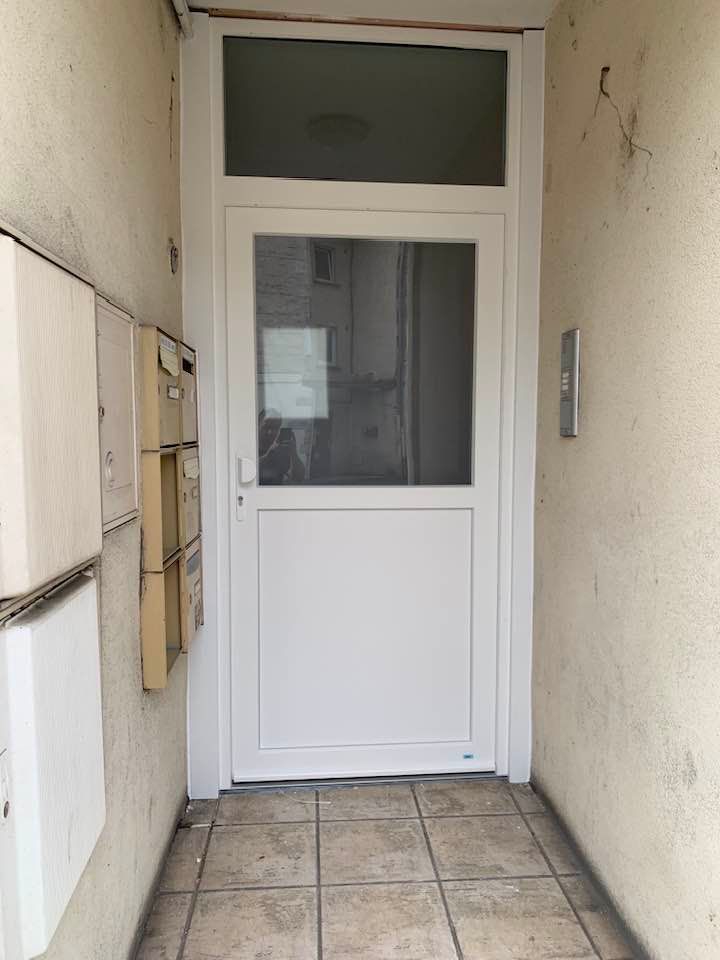 Remplacement d’une porte d'immeuble blanche