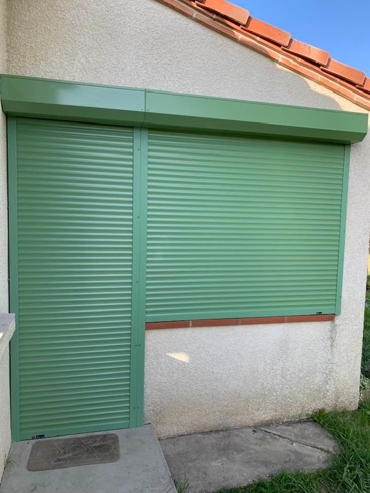 Volets électriques verts fermés sur porte et fenêtre