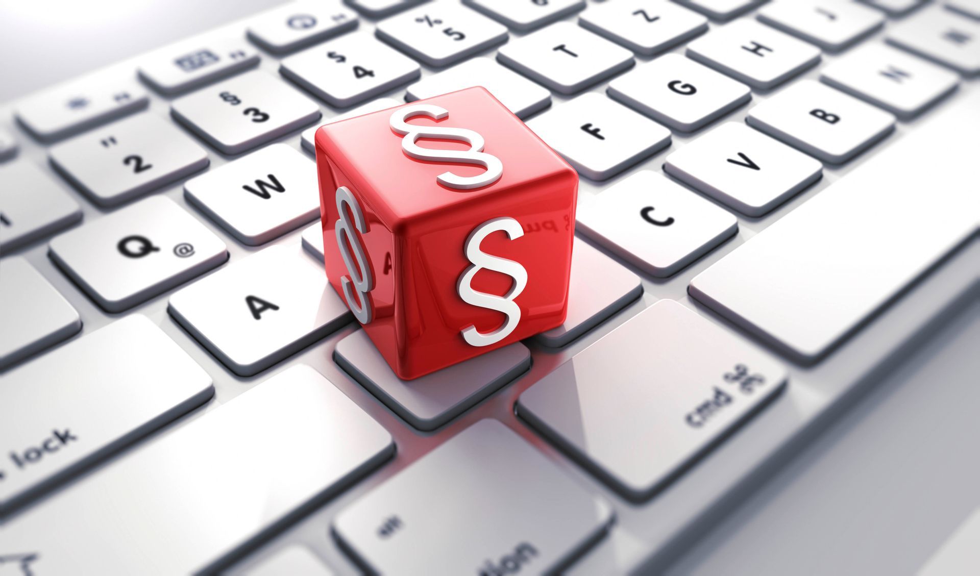 Roter Würfel mit weißen „§“-Symbolen auf einer Tastatur.