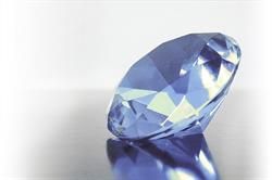 Eine Nahaufnahme eines blauen Diamanten auf einer weißen Oberfläche.