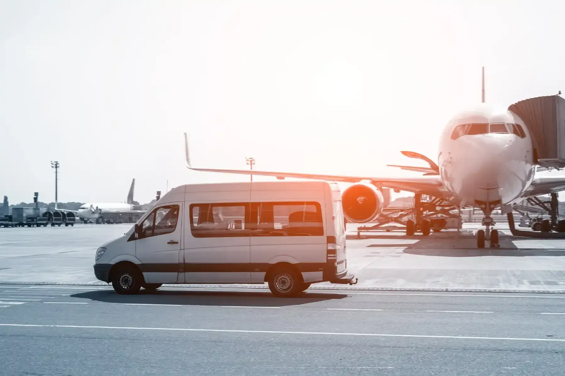 Una camioneta blanca está estacionada frente a un avión en un aeropuerto.