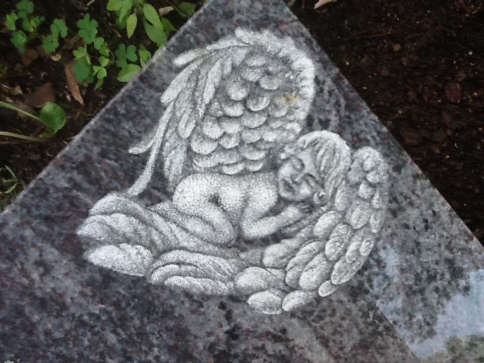 Schlafender Engel auf einem Grabstein