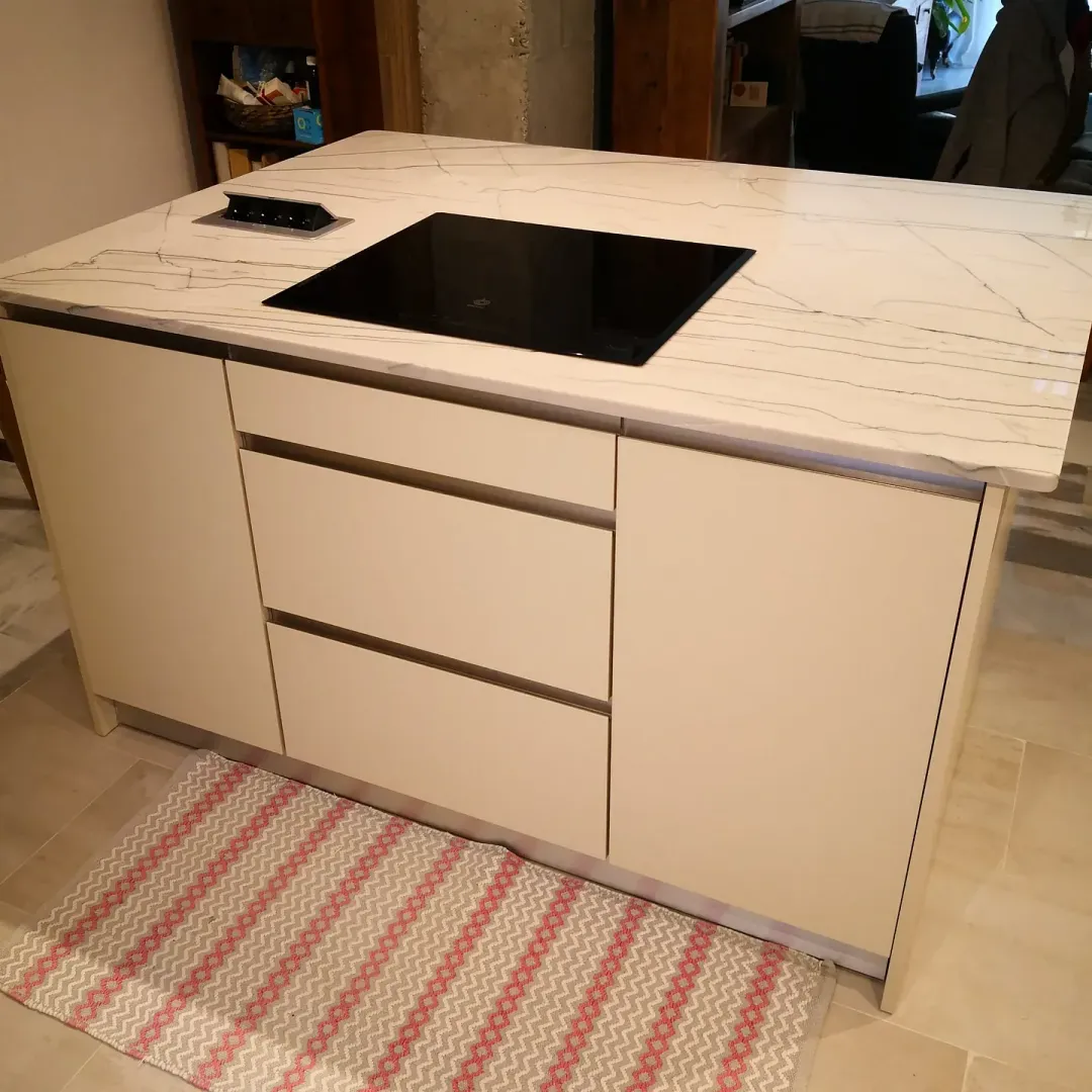 Una isla de cocina con un horno y una alfombra en el suelo.
