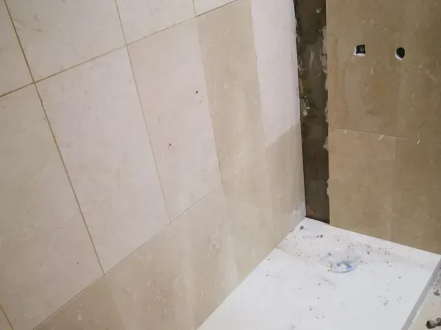 Un baño en construcción con azulejos en la pared y el piso.
